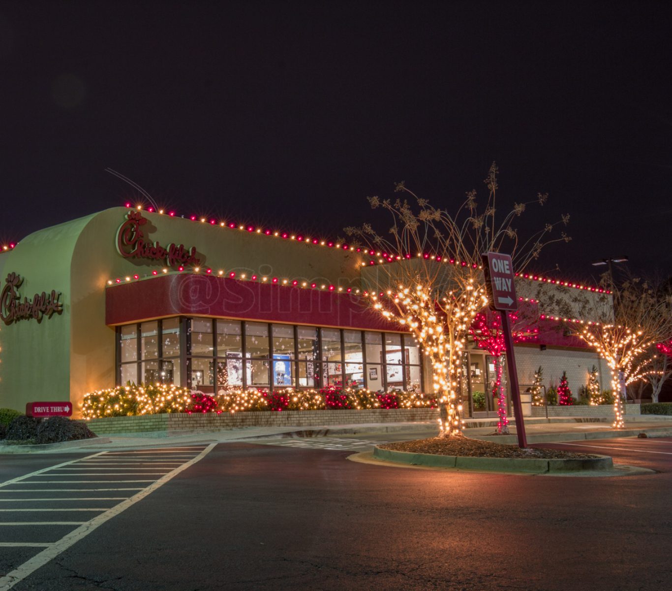 Professional installer placing Christmas lights on a two-story roof in Tarrant County