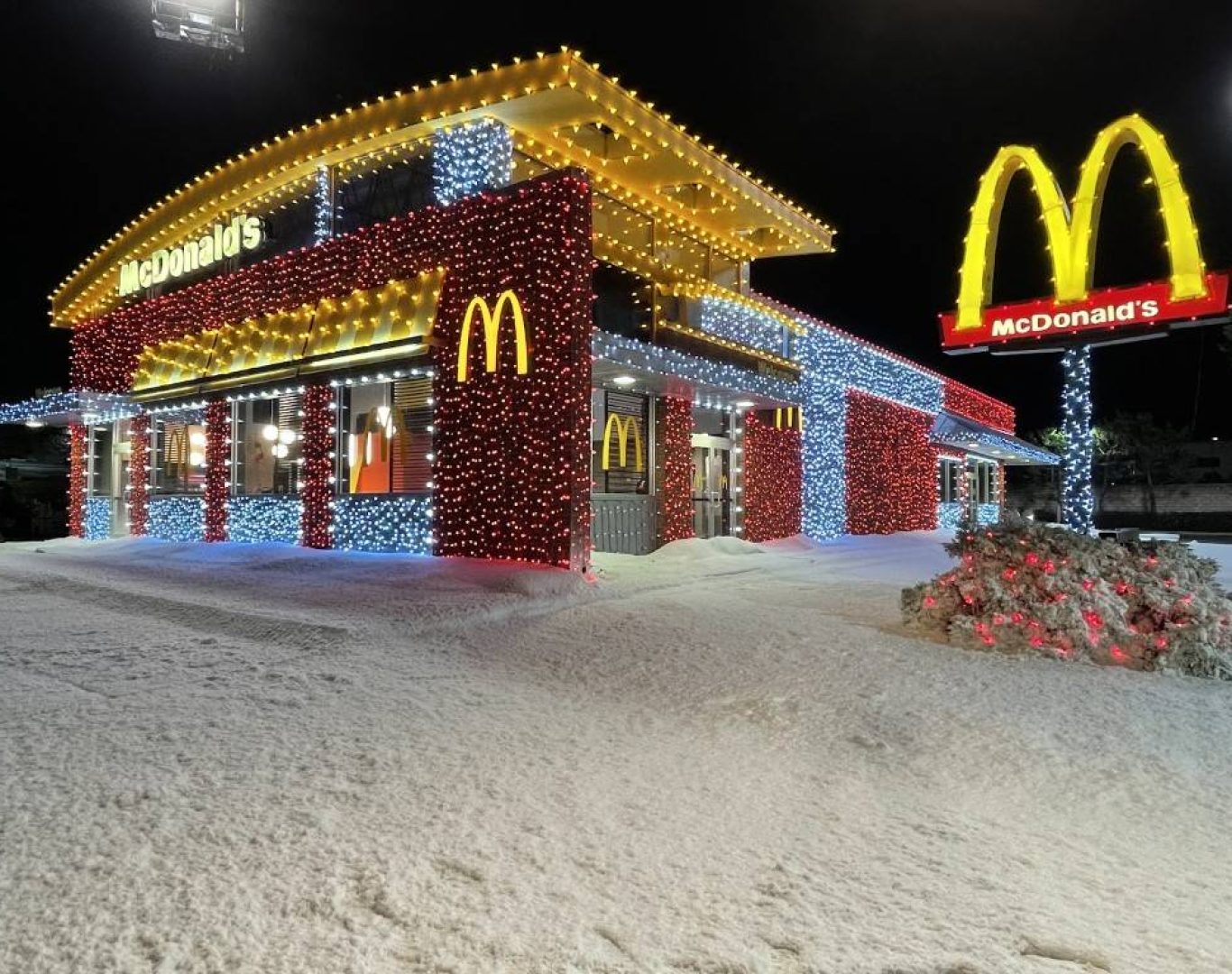 Professional installer placing Christmas lights on a two-story roof in Tarrant County